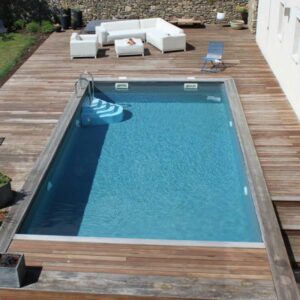 Piscine rectangulaire entourée d'une terrasse en bois dans un jardin de la région toulousaine