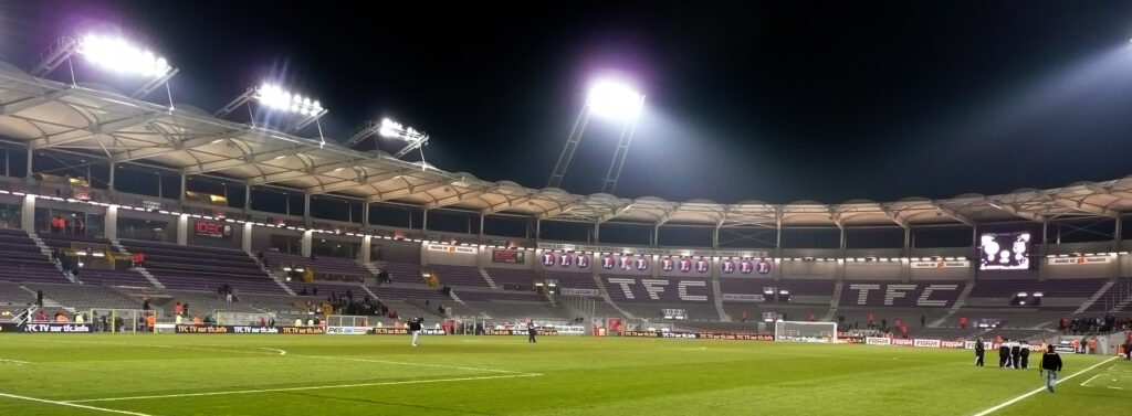 Pelouse et tribunes du Stadium de Toulouse éclairées en soirée