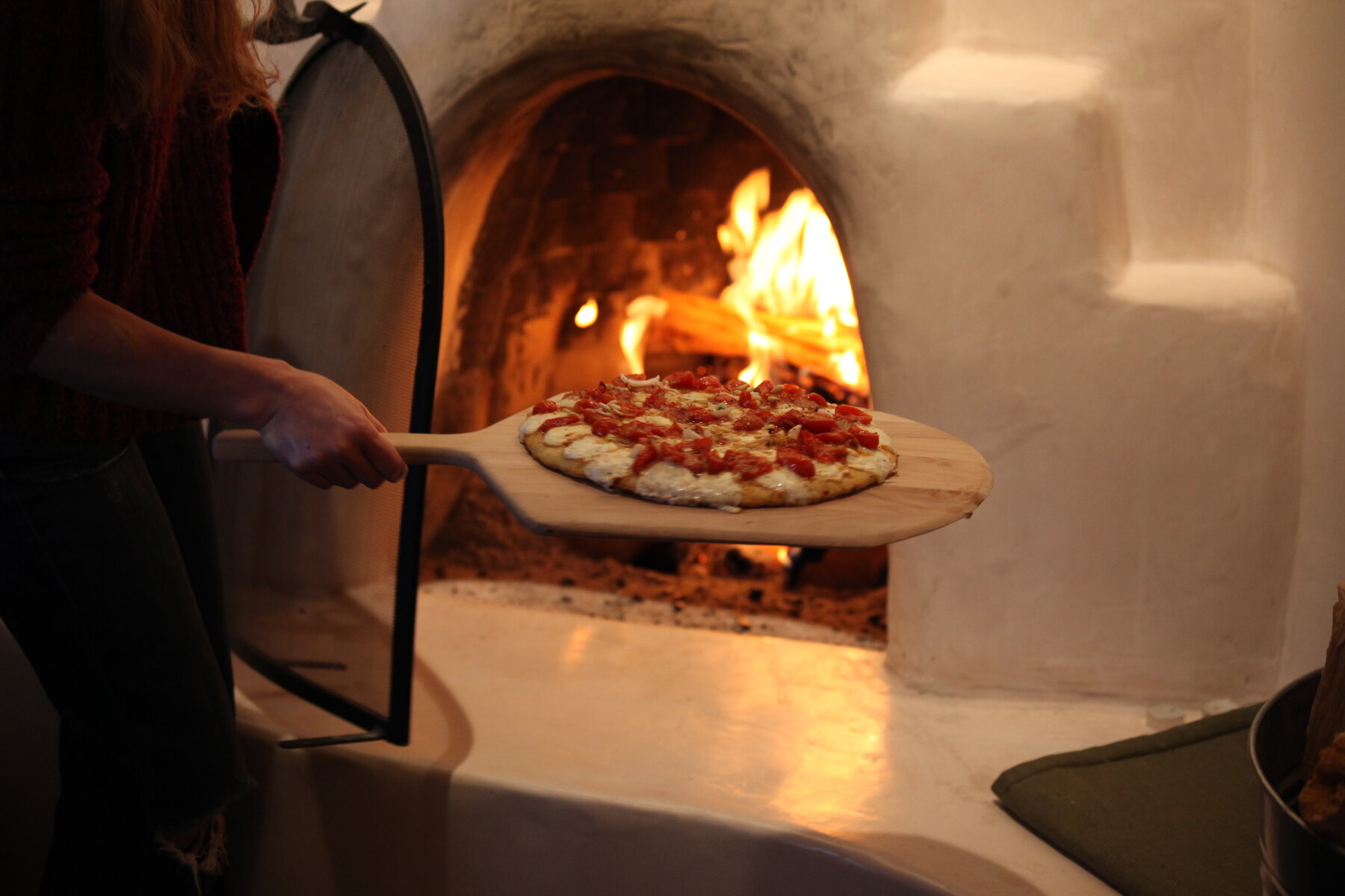 Pizza cuisant dans un four à bois, symbole des pizzerias historiques