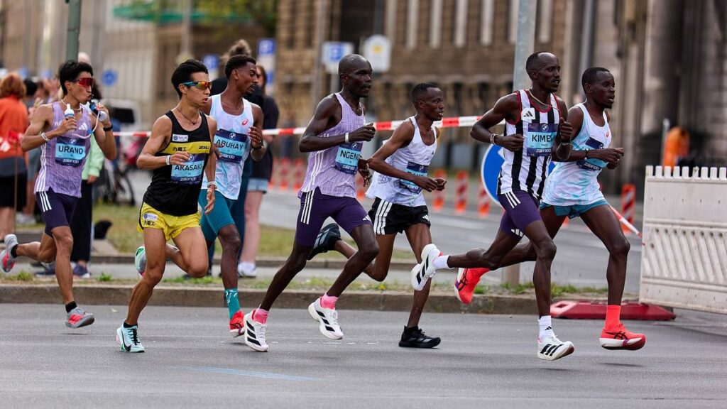 Coureurs de marathon en pleine course sur une avenue bordée de spectateurs