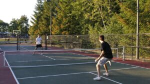 Deux joueurs disputent une partie de pickleball sur un terrain extérieur